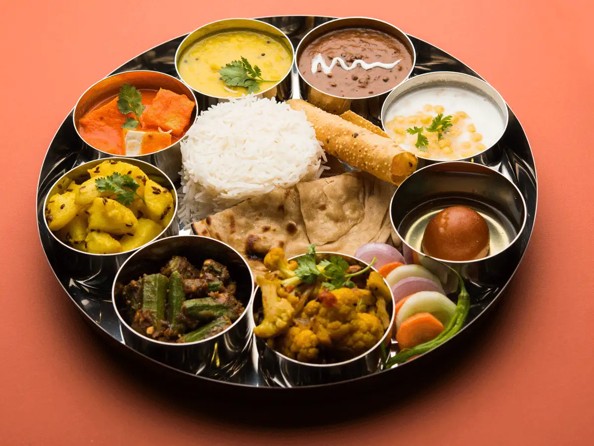 A traditional Indian thali meal with various curries, rice, and bread